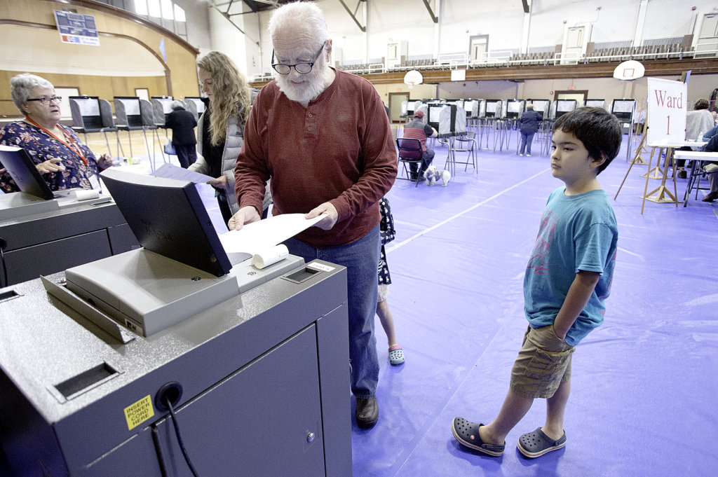 Jon Pitman casts his ballot at the Lewiston Memorial Armory. The merger vote was on the ballot. (Sun Journal file photo)