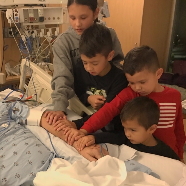 Jim and Pam Dumont's grandchildren pray for him to awaken from his coma in the ICU at Central Maine Medical Center in Lewiston. Soon after this photo was taken, Jim woke up. (Photo courtesy Dumont family)