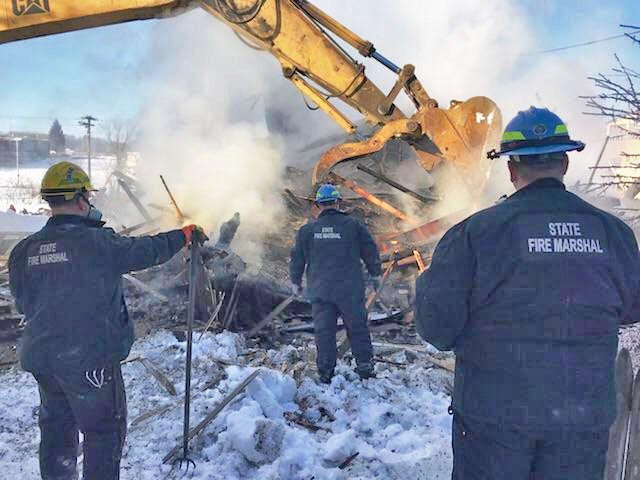 State fire officials search the rubble of house destroyed by fire in Millinocket on Thursday.