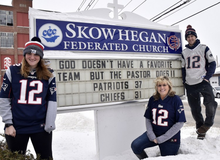 Members of the Mark and Deb Tanner family, hardcore fans of the New England Patriots, gather around a sign at the Federated Church in Skowhegan on Monday. Deb Tanner, center, is flanked by children Kaley and Josh. Her husband, the Rev. Mark Tanner, is out of state this week but picked the correct score of the AFC championship game against the Kansas City Chiefs.