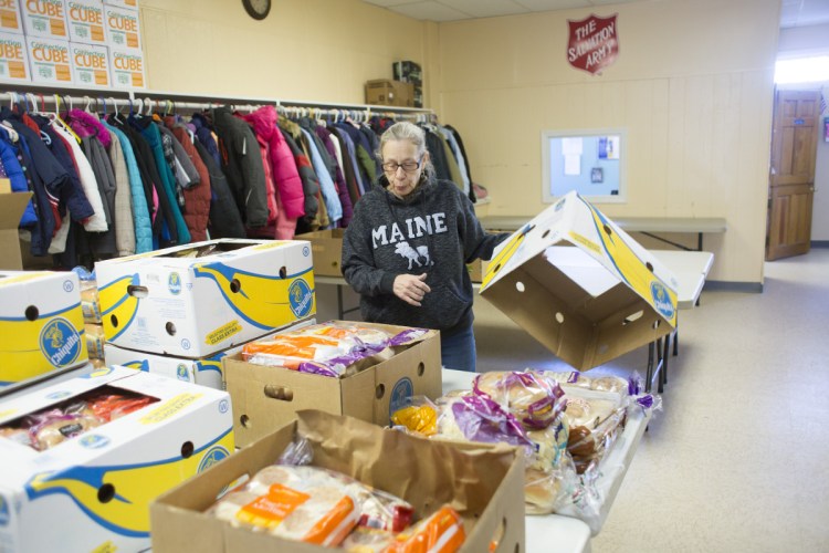 Volunteer Deborah Berry sorts food donations Thursday at the Salvation Army in Sanford. A safe containing $1,700 in donations was burglarized over Christmas, but the community quickly covered the loss. And then some.