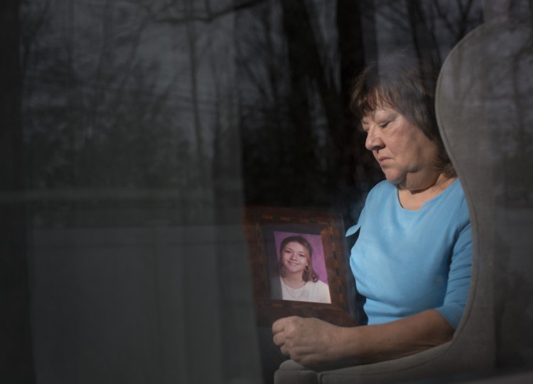 Lise Ouellette of Old Orchard Beach holds a portrait of her daughter Ashley, who was killed 20 years ago in a case that remains unsolved. "There's no time limit on grieving," says the anguished mother, who still hopes for resolution. "I just want to know why."