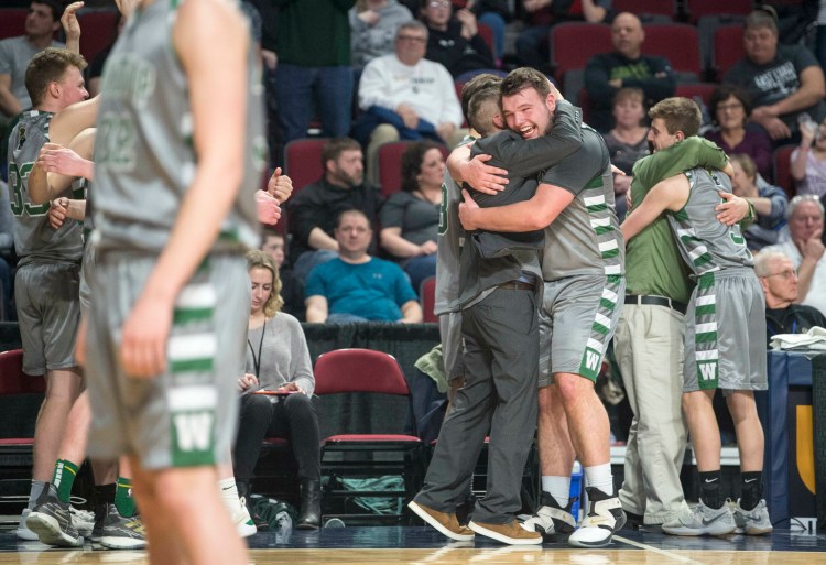 Winthrop boys basketball coach Todd McArthur embraces Sam Figueroa after the Ramblers won the Class C state championship game Saturday night at the Cross Insurance Center in Bangor.