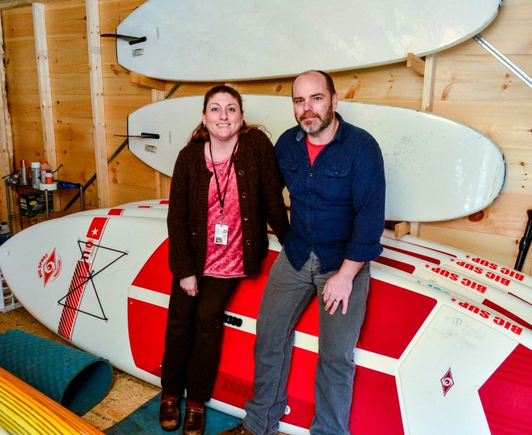 Angie Wing, left, and Keith Bellefleur stand in their rental standup paddle board storage shed on Wednesday at their Gardiner home. 