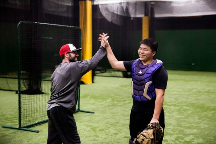 Princehoward Barbecue Yee high-fives his coach, Marcus Crowell, during his training at Hitters Count in Saco last week. Yee, 16, trains for three hours a day five days week.
