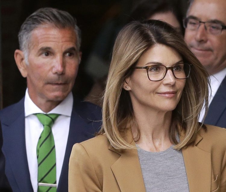 Actress Lori Loughlin, front, and husband, clothing designer Mossimo Giannulli, depart federal court in Boston on Wednesday.