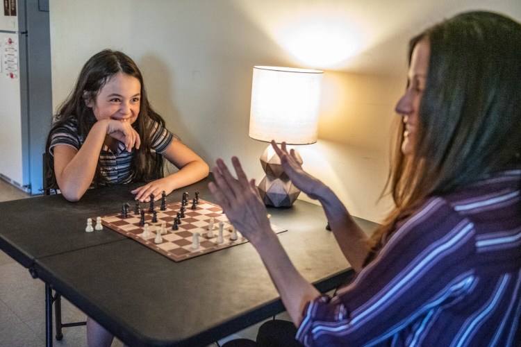 Samari, 10, teaches her mother, Michele Webb, how to play chess Oct. 20 at their house in Lewiston. Webb says she home-schooled her daughter last year, but the two decided public school was a better fit, so Samari is back at school this year. The girl learned to play chess as part of her home schooling, and continues to enjoy the game.