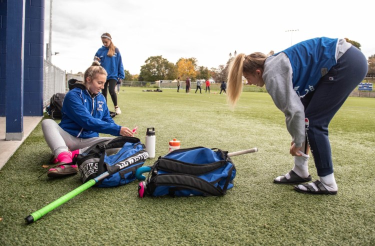 Alexis Freeman, left, makes a Facetime video call Tuesday to her Lewiston High School field hockey teammate who is home with COVID-19. Alexis' sister, Madison, gets ready for practice on the right.