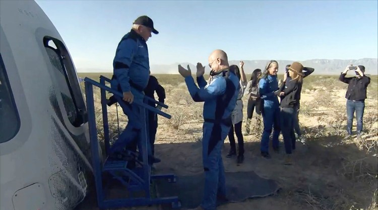 William Shatner gets off the Blue Origin capsule as he is greeted by Jeff Bezos near Van Horn, Texas, on Wednesday.  The “Star Trek” actor and three fellow passengers hurtled to an altitude of 66.5 miles over the West Texas desert in the fully automated capsule, then safely parachuted back to Earth in a flight that lasted just over 10 minutes.