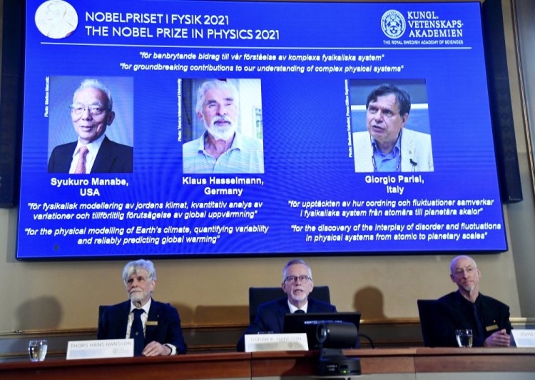 Secretary General of the Royal Swedish Academy of Sciences Goran Hansson, center, flanked at left by member of the Nobel Committee for Physics Thors Hans Hansson, left, and member of the Nobel Committee for Physics John Wettlaufer, right, announces the winners of the 2021 Nobel Prize in Physics at the Royal Swedish Academy of Sciences, in Stockholm, Sweden, on Tuesday. The Nobel Prize for physics has been awarded to scientists from Japan, Germany and Italy.