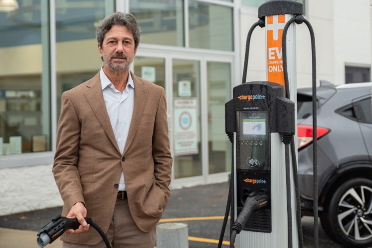 Adam Lee, chairman of Lee Auto Malls, stands by an electric car charging station Saturday at the Honda dealership in Auburn. The dealership, like many others, is having trouble meeting demand for all vehicles, including electric.