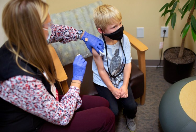 Neal Zimmerman, a 6-year-old from Brunswick, receives a COVID-19 vaccination  from Kate Sawyer, RN, at Maine Medical Partners Falmouth Pediatrics on Wednesday.