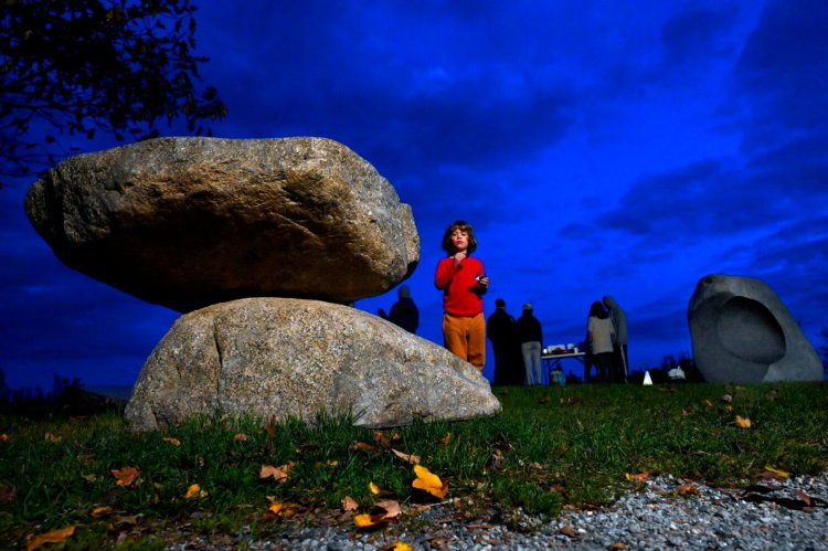 Jago Reinharz-Trainor, 5, of Portland looks over the piece "Gathering Stones," by the artist Jesse Salisbury while enjoying a snack during a reception Thursday at Fish Point on Portland's Eastern Promenade in 2021.