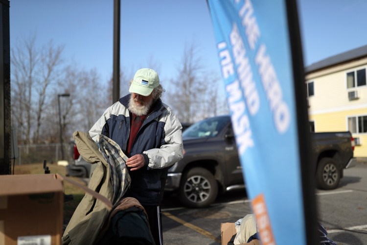 SOUTH PORTLAND, ME - NOVEMBER 18: Reggie Humphrey rummages through free clothing provided to homeless people living at Days Inn in South Portland. (Staff photo by Ben McCanna/Staff Photographer)