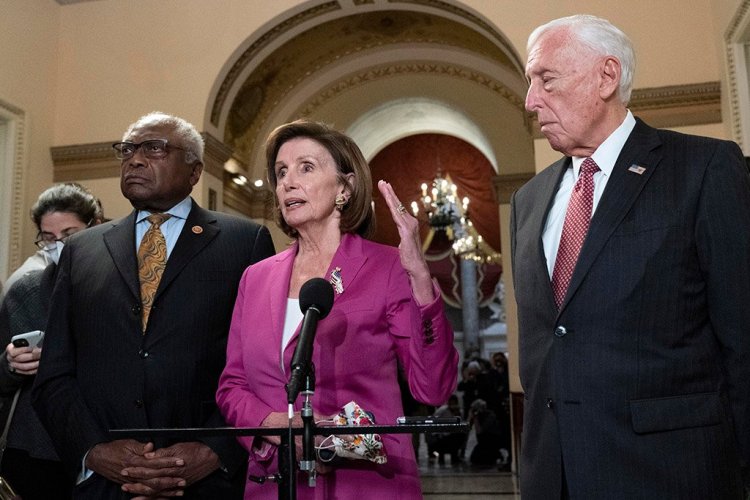 House Speaker Nancy Pelosi, accompanied by House Majority Whip James Clyburn, left, and House Majority Leader Steny Hoyer, speaks to reporters at the Capitol on Friday as the House considered President Biden's $1.85 trillion domestic policy package.