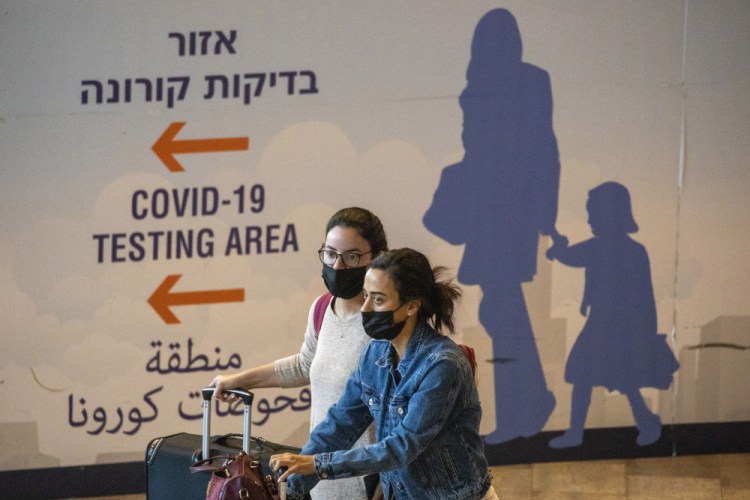 Travelers arrive at Ben Gurion Airport near Tel Aviv, Israel, on Sunday. Israel on Sunday barred entry to noncitizens and will use controversial technology for contact tracing. 