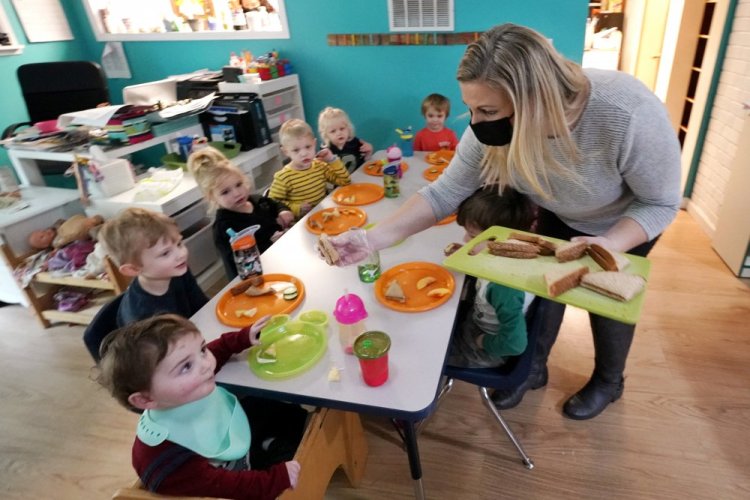 Amy McCoy serves lunch to preschoolers at her Forever Young Daycare facility, Monday, Oct. 25, 2021, in Mountlake Terrace, Wash. 