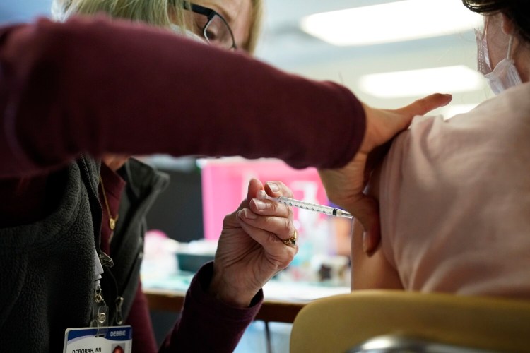 CAPE ELIZABETH, ME - NOVEMBER 19: Debbie Breton, a nurse with Northern Light Health, administers a Pfizer vaccine to a sixth-grade student at Memorial Middle School during a clinic at the South Portland school on Friday, November 19, 2021. (Staff photo by Gregory Rec/Staff Photographer)