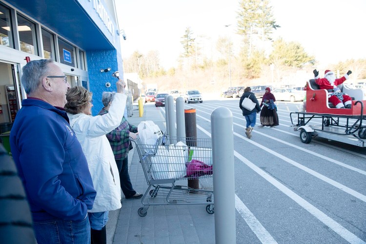 Paul LePage and his wife, Ann LePage, ring the bell Friday as Santa Claus rides by outside Walmart in Auburn. The former Maine governor was helping raise funds for The Salvation Army.