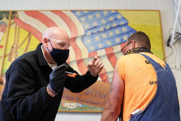 Richard Pierce of Hollis receives a booster dose of the Moderna vaccine from Steve Sloane, interim fire chief of the Westbrook Fire Department, during a walk-in clinic at the Westbrook Community Center last week. 