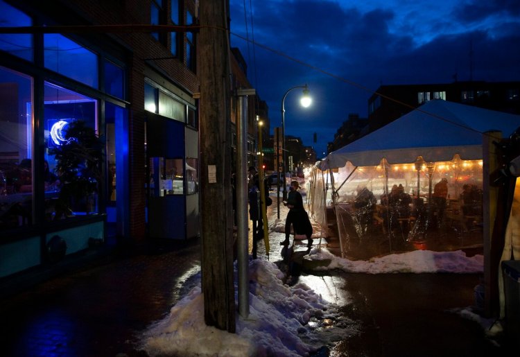 A hostess returns to the restaurant after seating diners in an outdoor area Tuesday at Eventide Oyster Co. in Portland.