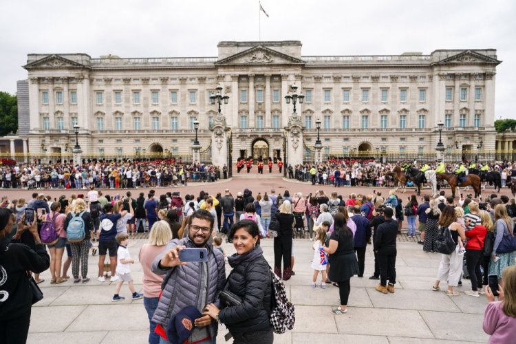 Members of the public watch the Changing of the Guard ceremony at Buckingham Palace, London, Aug. 23, 2021.