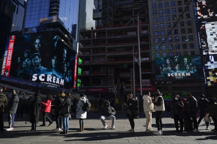 People wait in a long line to get tested for COVID-19 on Monday in Times Square, New York.