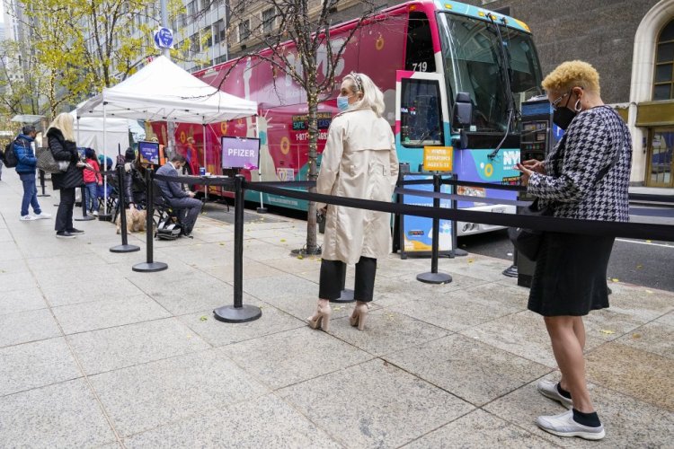 People wait in line for a COVID-19 vaccination at a NYC mobile vaccine clinic in Midtown Manhattan, Monday, Dec. 6, 2021. 