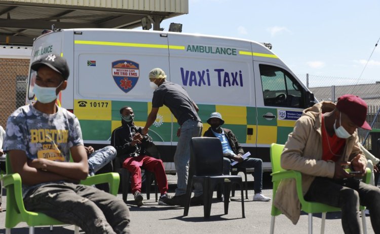 People wait to be vaccinated by a member of the Western Cape Metro EMS at a mobile "Vaxi Taxi" in Cape Town, South Africa, on Tuesday. Omicron accounts for more than 90 percent of all new infections in South Africa.