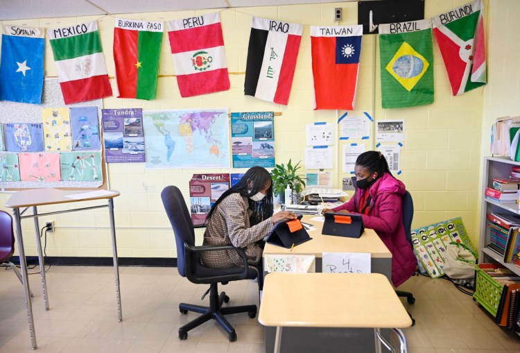 Divine Nsimba Lukombo 12, left, an 8th grader from the Democratic Republic of Congo, and 7th grader Odett Mavezo Junizi 12, also from the Congo, work together in a science class at  South Portland's Memorial Middle School.