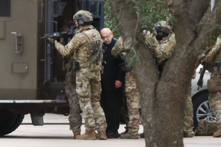 Shortly after 5 p.m., local time, authorities escort a hostage out of the Congregation Beth Israel synagogue in Colleyville, Texas, on Saturday. Police said the man was not hurt and would be reunited with his family. 