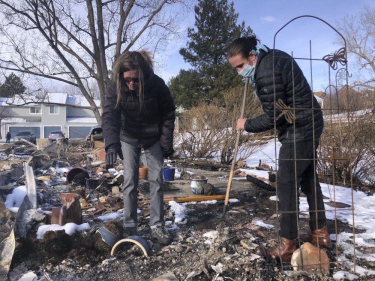 Karen England Horan and her son Robert, right, sift through the remains of her condo after it was destroyed by a wildfire that swept through her neighborhood in Louisville, Colo., on Tuesday. 