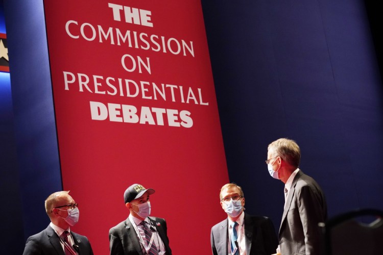 Officials from the Commission on Presidential Debates gather near the stage before the start of the second and final presidential debate on Oct. 22, 2020, at Belmont University in Nashville, Tenn. 