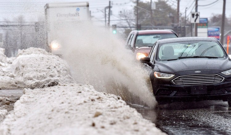 AUGUSTA, ME - FEBRUARY 8:  
A car splashes through a puddle Tuesday February 8, 2022 while heading heading west on Western Avenue in Augusta. Rain and warm temperatures causing snow melt led to large puddles in some areas. (Staff photo by Joe Phelan/Staff Photographer)