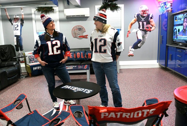 Toby Densmore, left, and Vanessa Novak stand in the Patriots room of their West Gardiner home Tuesday afternoon. Tom Brady, who won seven Super Bowls, officially announced that he was retiring from the NFL after 22 seasons.