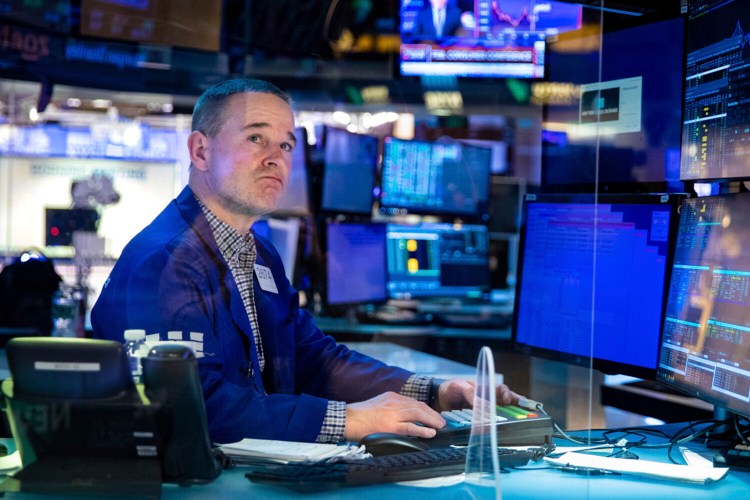 In this photo provided by the New York Stock Exchange, specialist Stephen Naughton works at his post on the trading floor, Tuesday, Feb 22, 2022. Stocks shifted between small gains and losses in morning trading on Wall Street Tuesday as tensions escalated in Ukraine over Russia's decision to send forces into that nation's eastern regions. (Allie Joseph/New York Stock Exchange via AP)