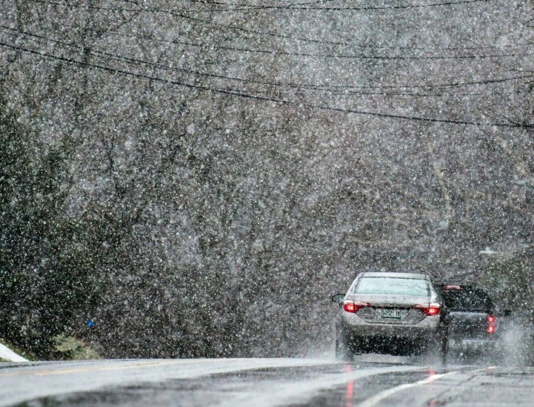 The morning rain storms switches over to snow Saturday as vehicles drive south on Water Street in Hallowell.
