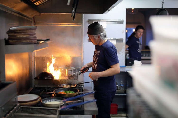 Flames leap from the grill as Sunny Chung sears steaks while his wife and business partner, Kim Lully, walks past the kitchen window at Maine Street Steak & Oyster in Brunswick. Amid pandemic-era challenges, they’re currently the only two employees, which simplifies things like scheduling and payroll, Lully jokes. But “we never call in sick. We never complain.”