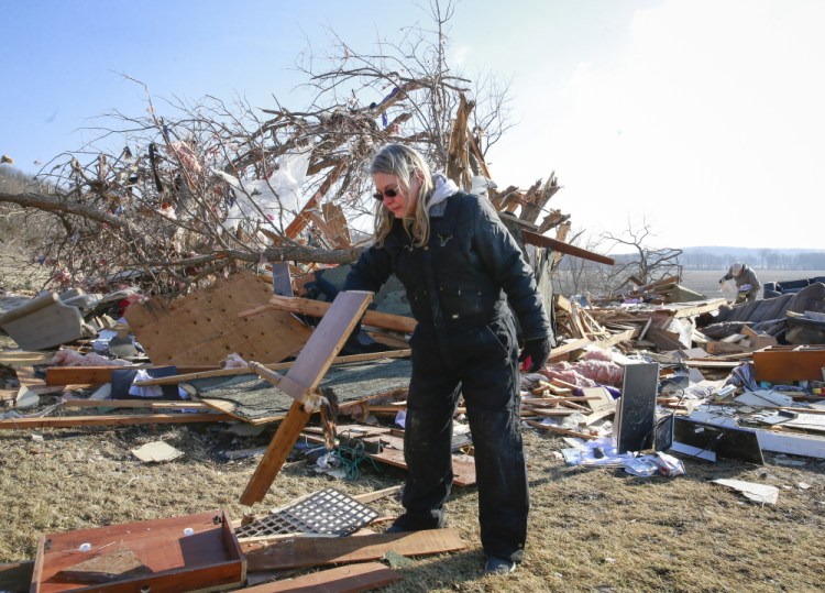 Betty Hope of Winterset, Iowa, searches for items worth keeping at her home as cleanup efforts are underway on Sunday after a tornado tore through an area southwest of town on Saturday.