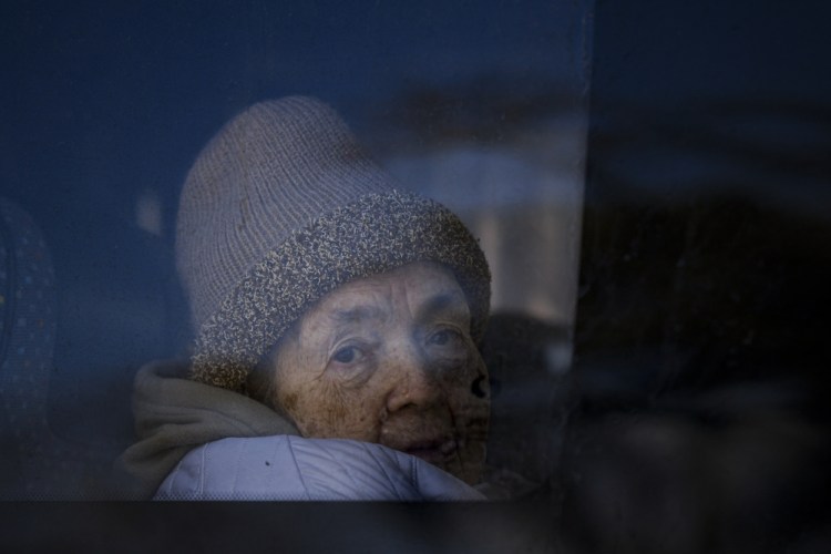 A refugee fleeing the war from neighboring Ukraine looks out a bus window after crossing the Romanian-Ukrainian border Monday in Siret, Romania.
