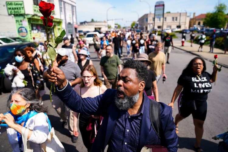 People march to the scene of a shooting at a supermarket in Buffalo, N.Y., on Sunday.