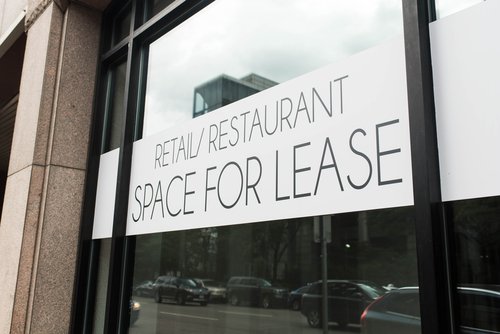 A banner in a window advertising commercial retail and restaurant space for lease