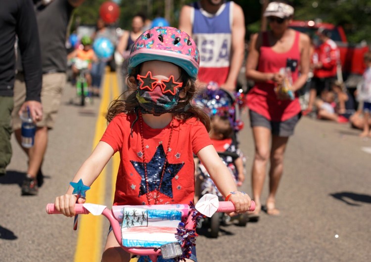 OCEAN PARK, ME - JULY 5: Wearing star sunglasses and with a drawing of the U.S. flag taped to her handlebars, Caelyn Celli [cq], 6, rides her bicycle in the Independence Day parade in Ocean Park on Monday, July 5, 2021. (Staff photo by Gregory Rec/Staff Photographer)