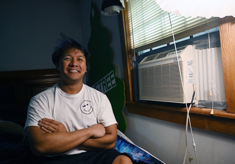 Marcus Cardona proudly shows off the AC unit in his home office/bedroom. When he grew up, his parents, from the Philippines, adopted the common Maine attitude that air conditioning is not needed here. 