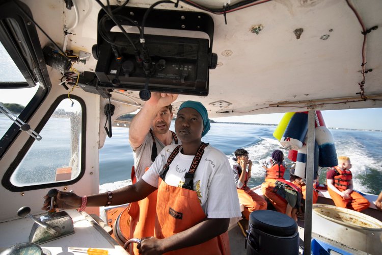 Ben Conniff teaches Flora Magaya, 18, how to navigate to lobster buoys seen on a GPS aboard the Sea Smoke in August. 