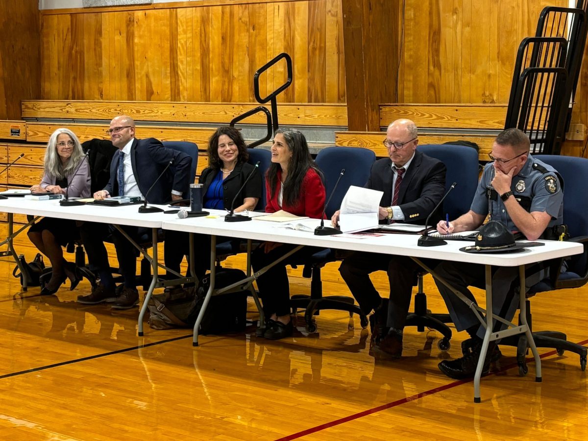 officials sit in gym
